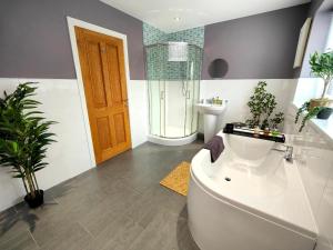 a bathroom with a tub and a toilet and a sink at Sanderson House in Cleator Moor