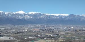 une ville avec des montagnes enneigées en arrière-plan dans l'établissement Guest Room安曇野2466, à Hitoichiba
