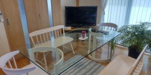 a living room with a glass table and chairs at Guest Room安曇野2466 in Hitoichiba