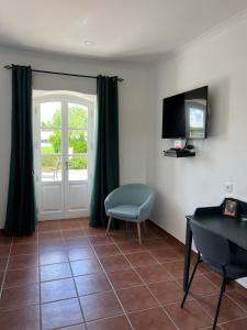 a living room with a table and a chair and a television at Quinta da Varzea in Raposa
