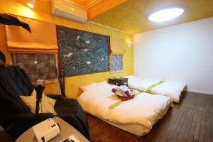 - une chambre avec 2 lits dans une chambre avec un projecteur dans l'établissement 1日1組限定Villa Dazaifu 露天風呂付1棟貸し, à Dazaifu