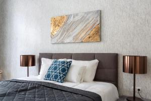 a bedroom with a bed with a painting on the wall at LH Gallery Apartments in Budapest