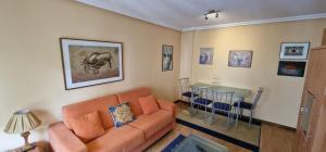 sala de estar con sofá y mesa en Raitán 2 - Apartamento con piscina para 4 pax, en Colunga