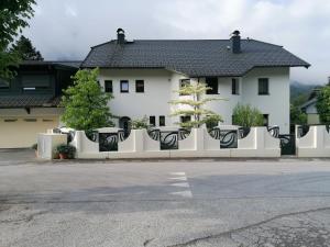 Appartment Nocksteinblick في Guggenthal: مبنى أبيض به سياج أبيض وطاولات