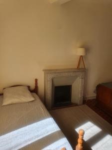 a bedroom with a bed and a fireplace at Chambre bleue La Baieta in Moulinet