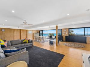 a living room with two couches and a dining room at The Black House in Arrawarra