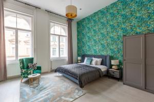 a bedroom with a bed and a green wall at LH Gallery Apartments in Budapest