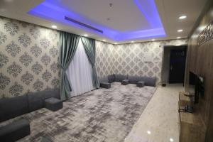 شقق نيروز ان للشقق المخدومة - Newroz N Serviced Apartments في الرياض: غرفة بها أريكة وتلفزيون وسقف