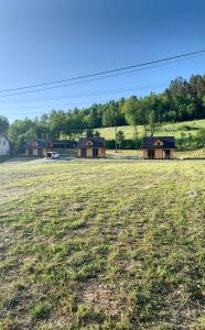 um grande campo com duas casas à distância em Domki Na Szlaku em Milówka