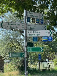 ein Straßenschild mit vielen Schildern an einer Stange in der Unterkunft Tiny House in Mariendorf