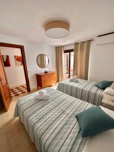 ein Hotelzimmer mit 2 Betten und einem Spiegel in der Unterkunft Apartamento vacacional Marbella centro La casita de la portera in Marbella
