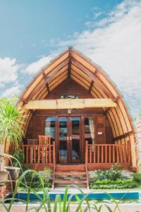 a large wooden cabin with a large glass door at Maha Nusa Menjangan in Banyuwedang