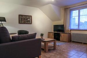 a living room with a couch and a table and a tv at Le Saint-Cyr, Centre-ville, Cosy, Spacieux in Issoudun