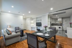 a dining room and living room with a table and chairs at Centre Point Chidlom in Bangkok