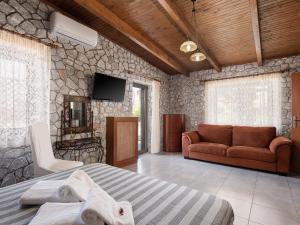 a room with a bed and a couch and a tv at Alkistis Sweet Homes in Stavros