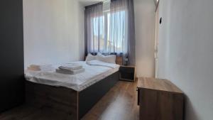 una camera da letto con un letto con lenzuola bianche e una finestra di Q Аpartment a Tsarevo
