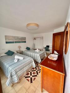 a hotel room with two beds and a dresser at Apartamento vacacional Marbella centro La casita de la portera in Marbella