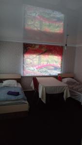 a room with two beds and a window at Керуен сарайы, гостиница in Aralʼsk