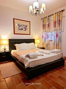 a bedroom with a large bed with two lamps and curtains at Elegant family house in Loulé with private pool in Loulé