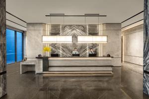 a lobby with two people at a reception desk at Citadines Qingshanhu Hangzhou in Hangzhou