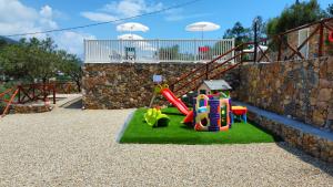 a childrens playground with a play set on grass at Agriturismo Monte Acuto - natura, mare & relax in piscina in Toirano