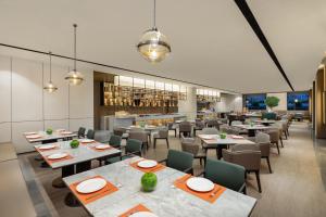 a restaurant with tables and chairs and a bar at Citadines Qingshanhu Hangzhou in Hangzhou