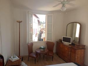 a room with a bed and a table and a mirror at Ca' del Portico in Valsolda