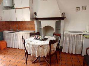 a table and chairs in a kitchen with a fireplace at Ca' del Portico in Valsolda