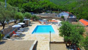 een zwembad in een resort met parasols bij Agriturismo Monte Acuto - natura, mare & relax in piscina in Toirano