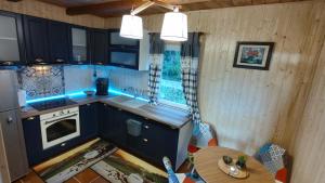 una vista aérea de una cocina con armarios azules y una mesa en Cabana 2 Râuri, en Bratca