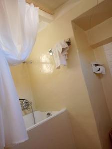 een badkamer met een bad, een wastafel en een douche bij Ca' del Portico in Valsolda