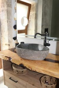 a bathroom with a stone sink on a wooden counter at ELVIRA LUXURY APT in Hersonissos