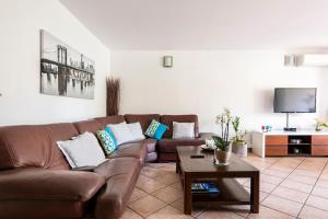 a living room with a brown couch and a table at Apartment Avenue Des Terrasses in Cassis