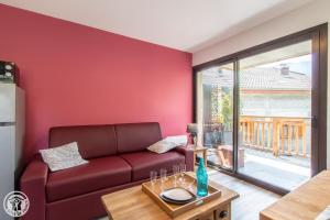 uma sala de estar vermelha com um sofá e uma mesa em Gite Annecy 101 - Au royaume des Castors - Appt 101 em Doussard