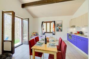 a kitchen with a wooden table and red chairs at Ca' Mia Panoramica - Happy Rentals in Lugano