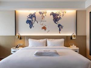 um quarto com uma cama grande e um mapa na parede em Kyriad Marvelous Hotel Kunming High-Tech Zone Wuyue Plaza em Kunming