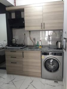 a kitchen with a stove and a washing machine at NOOR FAMILY APARTMENTS in Bursa