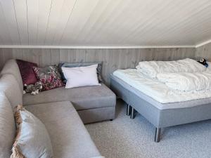 Zimmer mit Sofa, Bett und Ottomane in der Unterkunft Holiday home HOVDEN II in Hovden