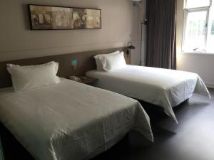 a hotel room with two beds and a window at Jinjiang Inn Yangzhou Slender West Lake Dongguan Street in Yangzhou