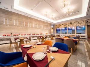 a dining room with tables and chairs and a restaurant at Kyriad Marvelous Hotel Heyuan Wanda Plaza in Heyuan