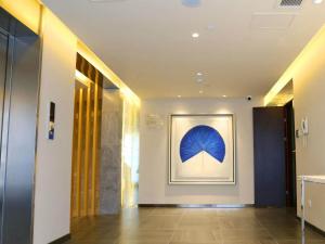 a hallway with a painting of a blue umbrella on the wall at Jinjiang Inn Yangzhou Gaoyou East Haichao Road in Gaoyou