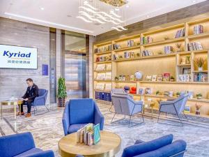 une personne assise à une table dans une bibliothèque dans l'établissement Kyriad Marvelous Hotel Guangzhou Baiyun International Airport, à Canton