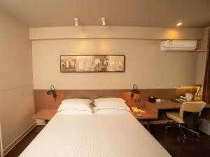 a bed in a room with a desk and a bed sidx sidx sidx at Jinjiang Inn Select Yangzhou Slender West Lake Siwangting Road in Yangzhou