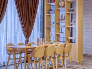 a dining room with a wooden table and chairs at Kyriad Marvelous Hotel Guangzhou Baiyun International Airport in Guangzhou