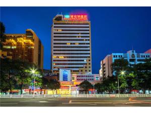 a large building with a red sign on top of it at Vienna Hotel Qingyuan City Square Lianjiang Road Hotel in Qingyuan