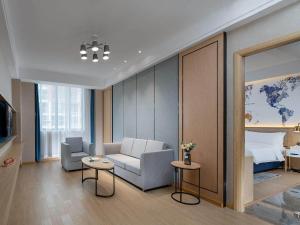a hotel room with a couch and a bed at Kyriad Marvelous Hotel Guilin Quanzhou in Quanzhou
