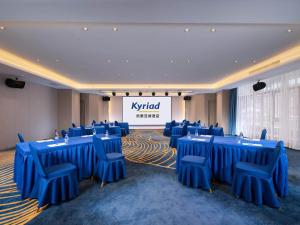 a room with blue tables and chairs and a stage at Kyriad Marvelous Hotel Hezhou Wanda Plaza in Hezhou +9 photos