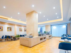 a lobby with a waiting room with tables and chairs at Vienna Hotel Lukou Airport in Jurong +6 photos