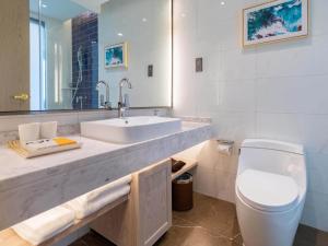 La salle de bains est pourvue d'un lavabo et de toilettes. dans l'établissement Kyriad Marvelous Hotel Shouguang Municipal Government, à Shouguang