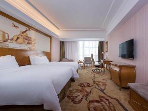防城的住宿－维也纳国际酒店广西东兴东盟大道店，酒店客房设有两张床和一台平面电视。